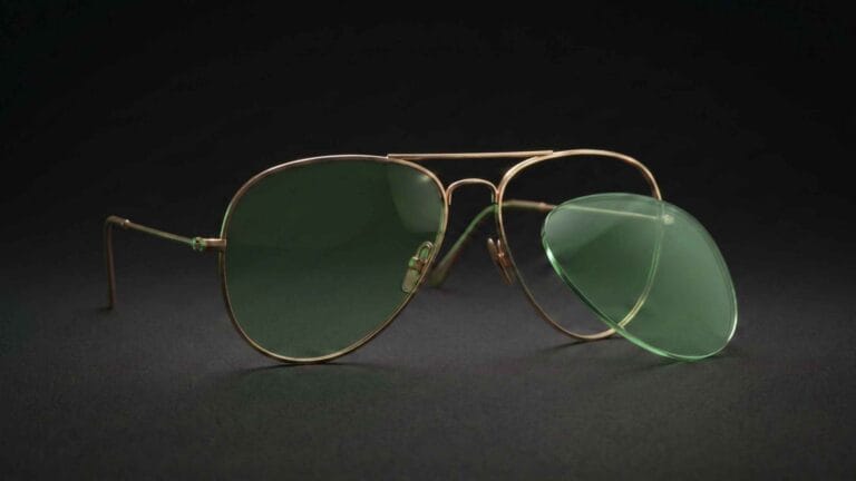 How to Replace Ray-Ban Aviator Lenses (RB3025 & RB3026) 1 Teardrop metal aviator-style sunglasses on a dark surface with one lens removed beside the frame