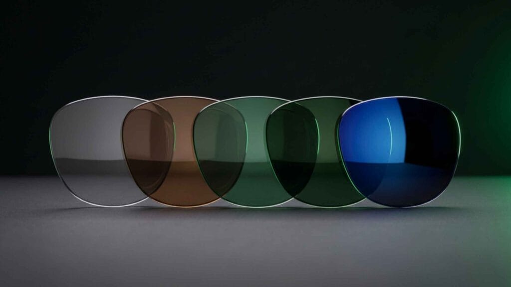 Row of replacement sunglass lenses in grey, brown and green tints on a dark surface