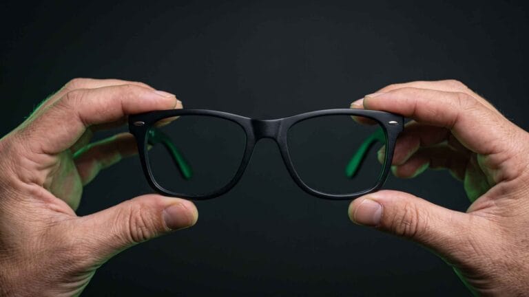 How to Replace Ray-Ban Wayfarer Lenses at Home (RB2140) 5 Hands holding a pair of black acetate Wayfarer-style sunglasses at eye level, front view